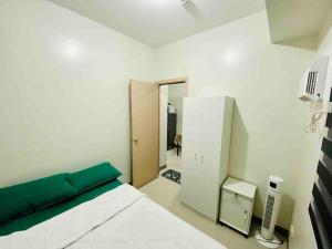 a white bedroom with a bed and a door to a hallway at Newly Furnished 2BR -Condo in Cainta Rizal in Manila