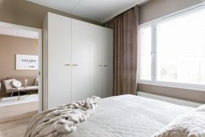 a bedroom with a white bed and a window at Cozy Room x Aurora Lights in Tampere