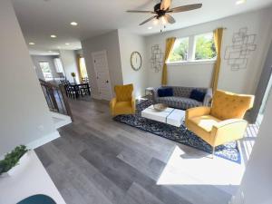 a living room with a couch and two chairs at 4 Story Queen City Retreat! New! Walk to Downtown! in Charlotte