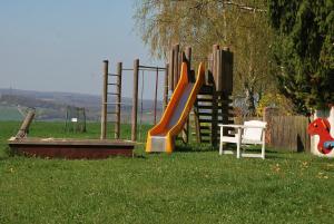 a playground with a slide in the grass at Hotel Waldschloss in Bad Camberg