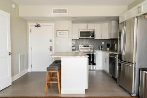 a kitchen with white cabinets and stainless steel appliances at CONDO ON MUSIC ROW w PARKING, SLEEPS 6, POOL in Nashville