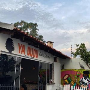 un restaurant avec un panneau sur le côté d'un bâtiment dans l'établissement HOSTEL YA DUDU E BISTRO, à Cuiabá