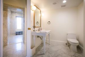 Baño blanco con lavabo y aseo en Swann House en Washington