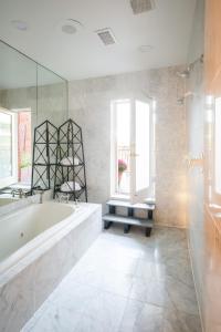 een witte badkamer met een bad en een raam bij Swann House in Washington