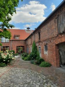 a brick building with a stone walkway in front of it at Ferienwohnung Großwulkow 