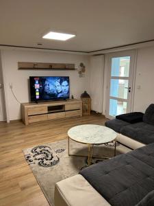 a living room with a couch and a flat screen tv at Family & Friends Hannover 75m2, Messe in Hannover