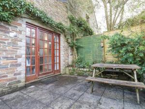 a wooden picnic table in front of a brick building at Minions Cottage in Bodmin