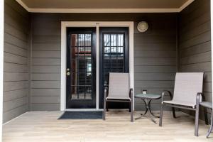 a front porch with two chairs and a door at Downtown Nashville Condo, Walk to Broadway with Free Parking in Nashville