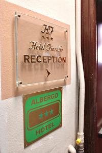 a sign for an albergo hotel on a wall at Hotel Fiorella Milano in Milan