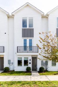 a white house with a balcony on top of it at Diamond Retreat Townhome 7 Beds 3 mi to Downtown in Nashville