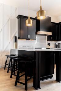 a kitchen with black cabinets and black stools at Diamond Retreat Townhome 7 Beds 3 mi to Downtown in Nashville