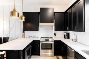 a kitchen with black cabinets and stainless steel appliances at Diamond Retreat Townhome 7 Beds 3 mi to Downtown in Nashville