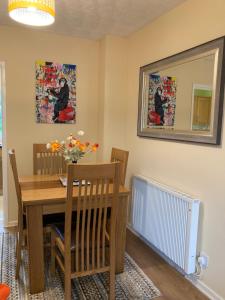 a dining room with a table and a mirror at Home from Home in our Self-Contained Annexe in Radwinter