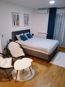 1 dormitorio con 1 cama grande y 2 sillas en Studio App Bulevar - free parking, en Sarajevo