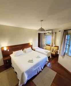 - une chambre avec deux lits et un canapé dans l'établissement Pousada O Garimpo., à Embu