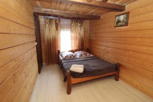 sypialnia z łóżkiem w drewnianym domku w obiekcie "Карпати" w mieście Jabłonica