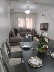 - un salon avec une table et un canapé dans l'établissement Joli appartement centre Casablanca, à Casablanca