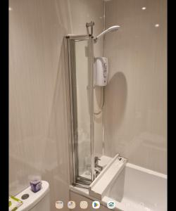 a bathroom with a shower and a sink with a mirror at Largs holiday flat in Largs