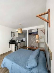 una camera con letto blu e una cucina di Cálido Home en corazón Ciudad Vieja a Montevideo