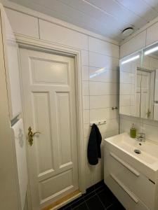 ein Badezimmer mit einer weißen Tür und einem Waschbecken in der Unterkunft Penthouse with panorama view and great location! in Tromsø