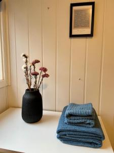 eine schwarze Vase mit Blumen und Handtüchern auf dem Tisch in der Unterkunft Penthouse with panorama view and great location! in Tromsø