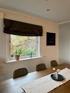 ein Esszimmer mit einem Tisch und einem Fenster in der Unterkunft Penthouse with panorama view and great location! in Tromsø