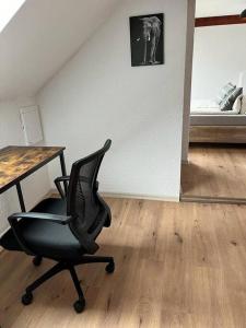 uma cadeira num quarto com uma secretária e uma cama em Apartment Mirabelle 5 em Püttlingen