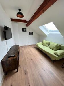 a living room with a green couch and a wooden floor at Apartment Mirabelle 5 in Püttlingen