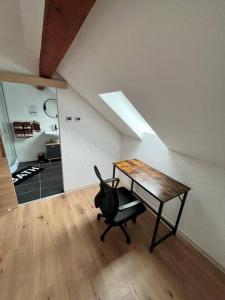 Pokój z biurkiem i krzesłem na poddaszu w obiekcie Apartment Mirabelle 5 w mieście Püttlingen