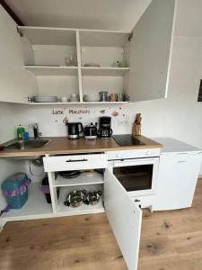 uma cozinha com armários brancos e uma bancada em Apartment Mirabelle 5 em Püttlingen