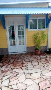 a house with a stone patio in front of a door at La cabane de Josephine in Le Lamentin