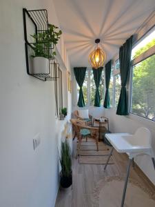 - un salon avec une table, des chaises et des fenêtres dans l'établissement Herăstrău Apartament 2, à Bucarest