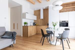 a kitchen and dining room with a table and chairs at Kamienica Parkowa in Dąbki