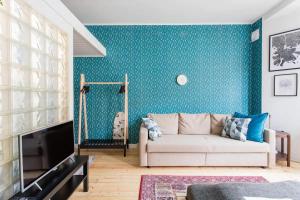uma sala de estar com um sofá e uma parede azul em Renovated Design District Studio em Helsinque