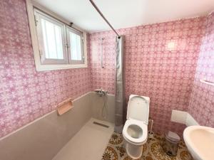 a pink bathroom with a toilet and a sink at Varosha View House 