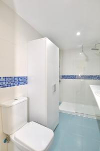 a white bathroom with a toilet and a shower at Casa Rosita in Santander