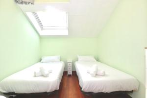 two beds in a small room with a window at Casa Rosita in Santander