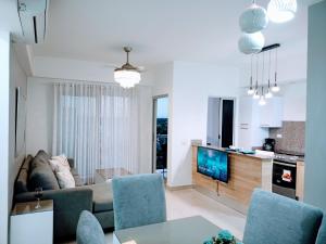 a living room with a couch and chairs and a kitchen at Confortable apto. en Boca Chica in Boca Chica