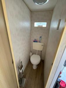 a small bathroom with a toilet and a window at Lake District Caravan in Cockermouth