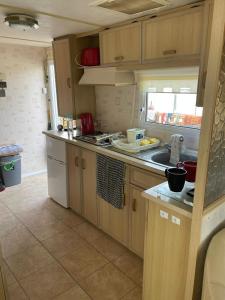 a kitchen with wooden cabinets and a counter top at Lake District Caravan in Cockermouth