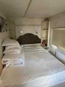 a bedroom with a large white bed with pillows at Lake District Caravan in Cockermouth