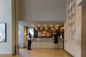 two people standing at a counter in a lobby at Elegant Flat Paulista Alameda Campinas Garagem , Pool, Ar Cod, in Sao Paulo +268 photos