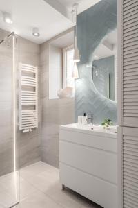a bathroom with a sink and a mirror at Sanhaus Apartments - Apartament LIDO - 300 m od plaży in Sopot