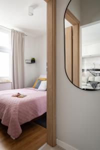 - une chambre avec un lit et un miroir dans l'établissement Sanhaus Apartments - Apartament LIDO - 300 m od plaży, à Sopot