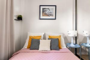 a bedroom with a bed with a pink blanket at Sanhaus Apartments - Apartament LIDO - 300 m od plaży in Sopot