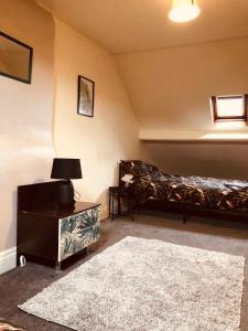 a bedroom with a bed and a table with a lamp at The Brown Box Holiday Let in Loftus