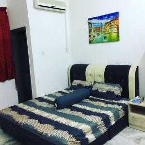 ein Schlafzimmer mit einem Bett mit einer blauen und weißen Decke in der Unterkunft Hz Homestay Bertam in Kepala Batas