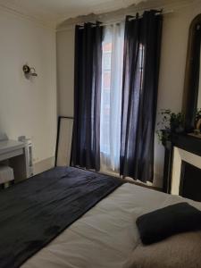 a bedroom with a large bed and a window at L'appartement Idéal 4 voyageurs in Boulogne-Billancourt