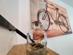 eine Flasche mit Steinen auf einem Tisch mit einem Fahrradgemälde in der Unterkunft Vigny du lac in Publier