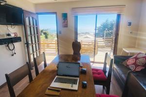 a laptop sitting on a wooden table in a living room at Moderna Casa - Playa Puertecillo in Navidad
